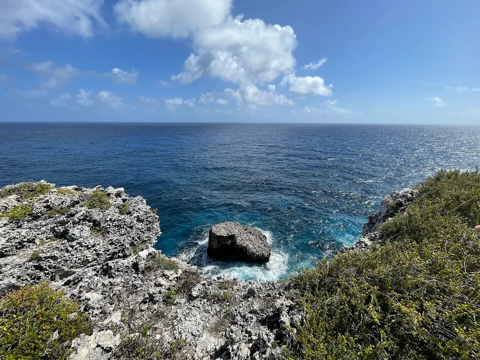 View from the limestone Bluff on Cayman Brac over turquoise sea to a small offshore islet