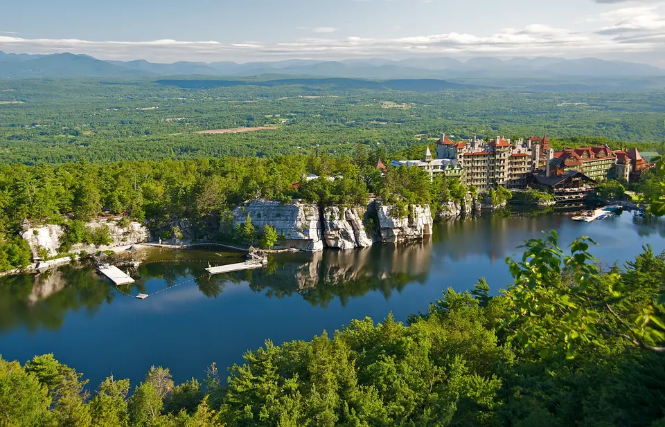 Lake Mohonk framed by trees and cliffs, seen from a hiking trail at Mohonk Mountain House