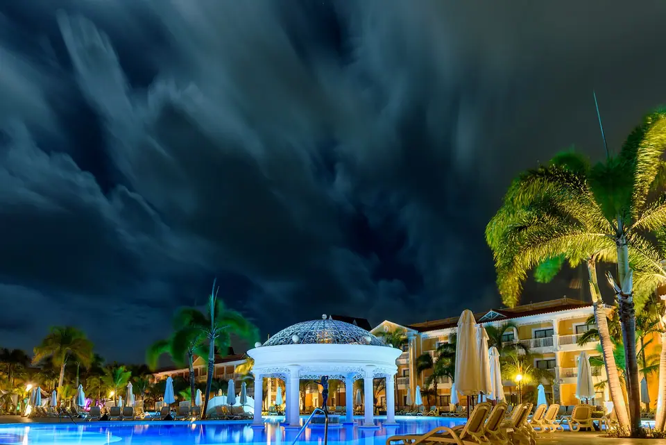 Long-exposure photo of a large resort pool with palm trees at dawn at a Bahia Principe resort in Punta Cana