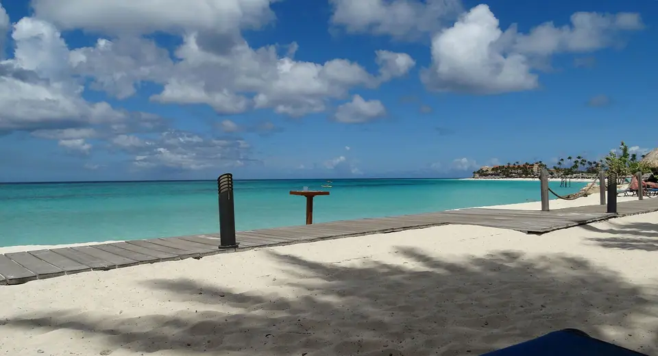 Wooden boardwalk along white sand and turquoise water at the Divi and Tamarijn resorts on Druif Beach, Aruba