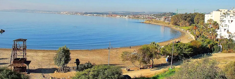 Small sandy cove and calm water at Playa del Cristo in Estepona, Spain