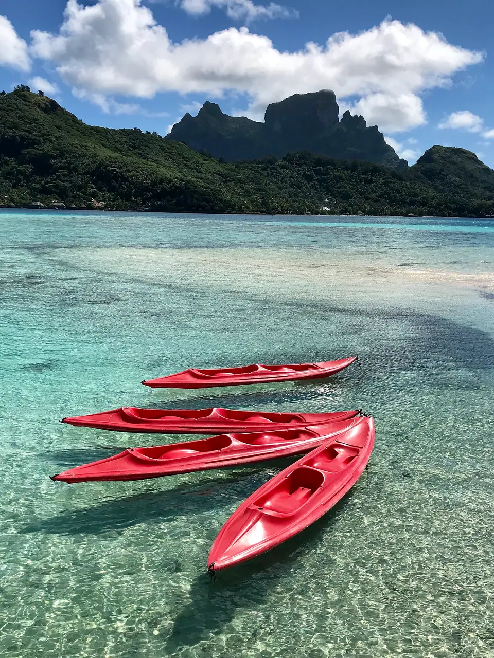 Boat on the clear lagoon of Bora Bora with Mount Otemanu in the background