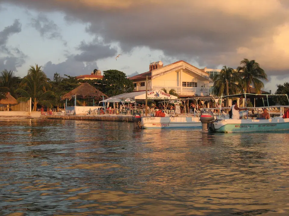 Calm turquoise water and a low island shoreline at Isla Mujeres just before sunset