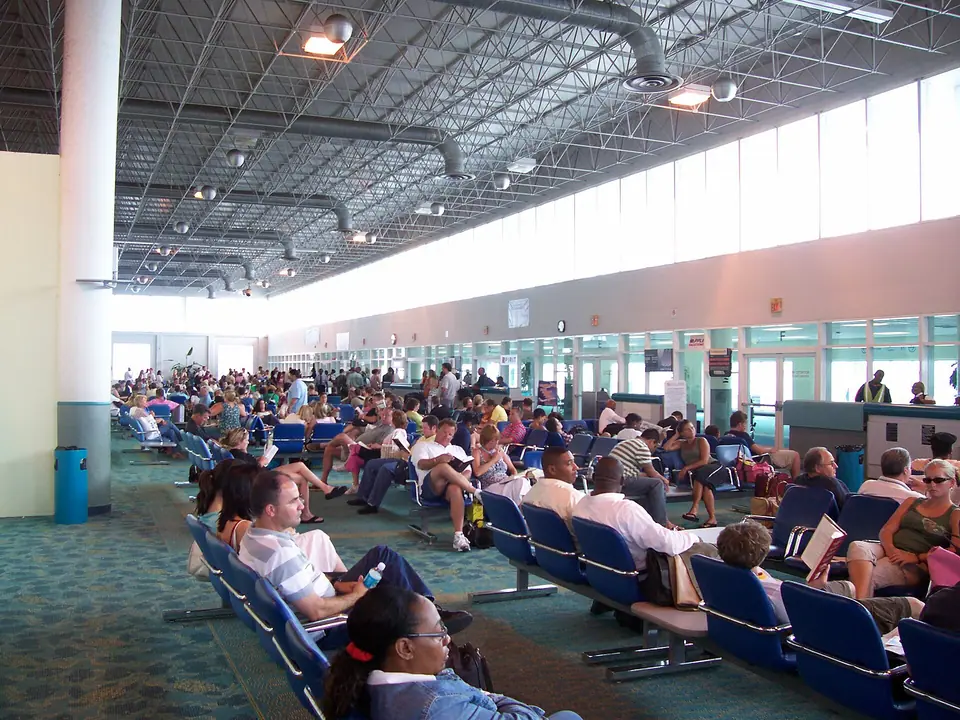 Passengers seated in the U.S. departures lounge at Lynden Pindling International Airport in Nassau