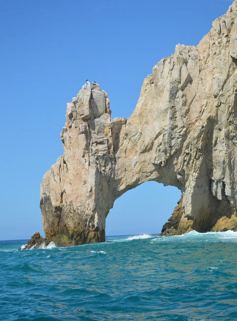 El Arco rock formation at Land's End rising out of deep blue water
