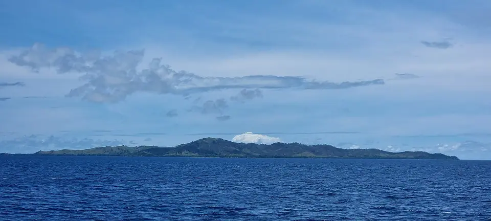 Wide view of Malolo Island, Fiji, with beach, palms and reef