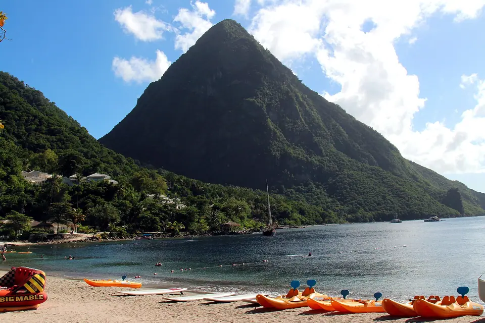 Petit Piton rising steeply behind a small beach lined with kayaks between the Pitons