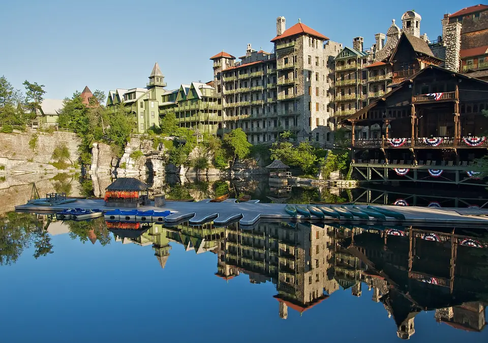 Wooden boat dock on Lake Mohonk in front of the long stone and timber guest wings of Mohonk Mountain House