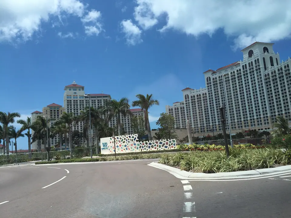 Tall pale towers of the Baha Mar resort complex on Cable Beach, Nassau, behind palm trees and a curving road