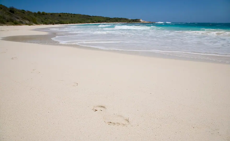 Crescent of white sand and turquoise water at Half Moon Bay on Antigua's east coast