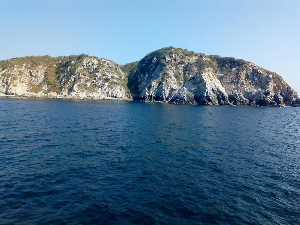 Sheltered green-blue bay with a sandy beach and forested hills at Huatulco, Oaxaca
