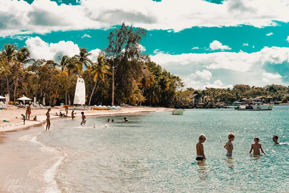 Calm turquoise water and a sandy beach lined with palms at Casa de Campo in La Romana