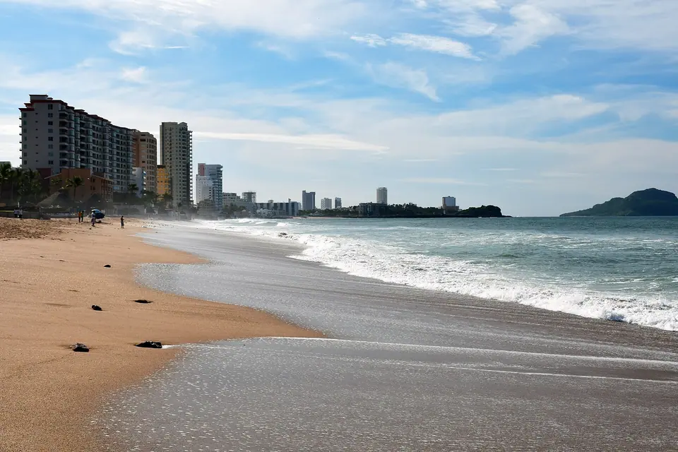 Long sandy beach and Pacific surf in Mazatlán's Zona Dorada with hotels behind