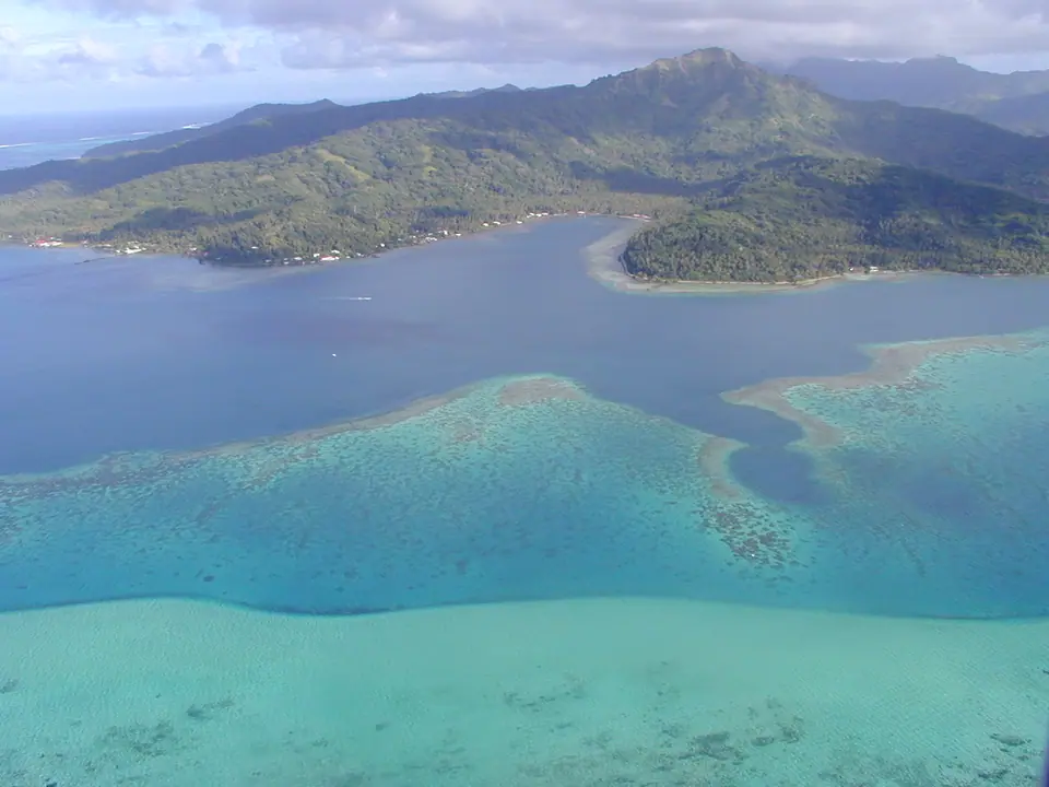 Aerial view of Taha'a island and its lagoon ringed by reef motus