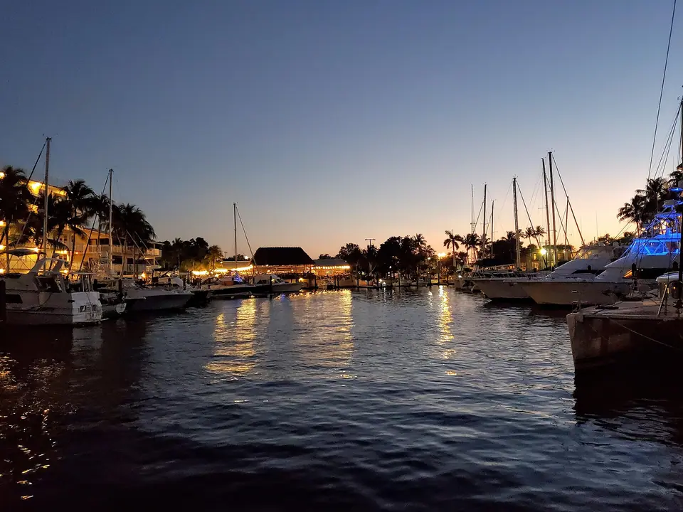Boats and calm water at a Key Largo marina under a pink and blue dusk sky