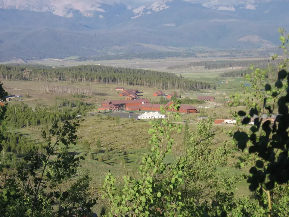 Lodges and meadow at a mountain ranch in Grand County, Colorado, seen from a hilltop cabin