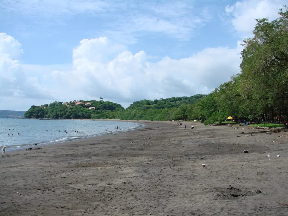 Curving beach with green hills and calm water at Playa Panamá, Guanacaste