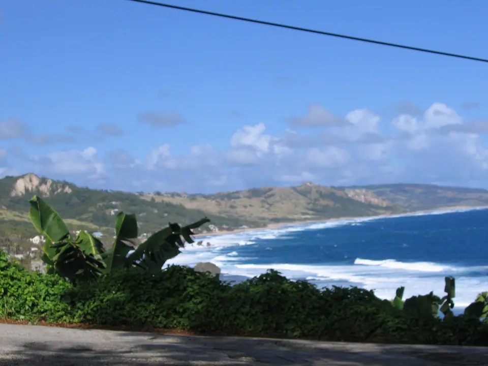 Atlantic surf breaking along the rugged east coast near Bathsheba with green hills behind
