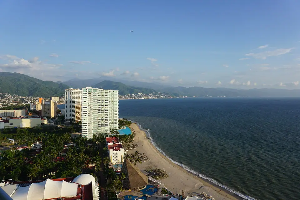 Wide view across Banderas Bay with green mountains and the Puerto Vallarta shoreline