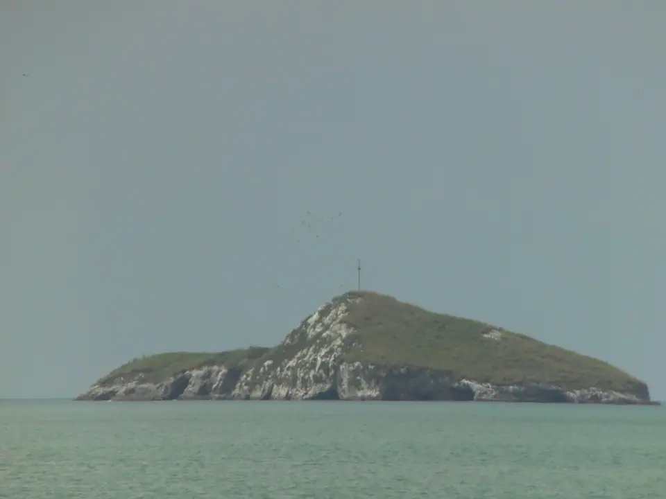 Rocky Farallón islet just off a wide sandy beach on Panama's Pacific coast