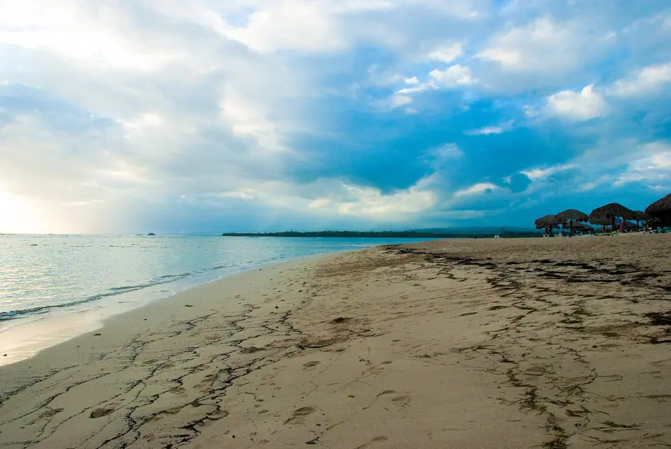 Golden sand beach with palm trees and calm water at Playa Dorada near Puerto Plata