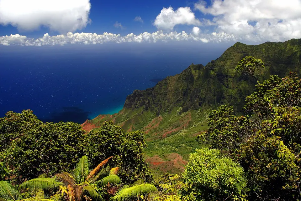 Green fluted cliffs of the Na Pali Coast on Kauai dropping into the ocean