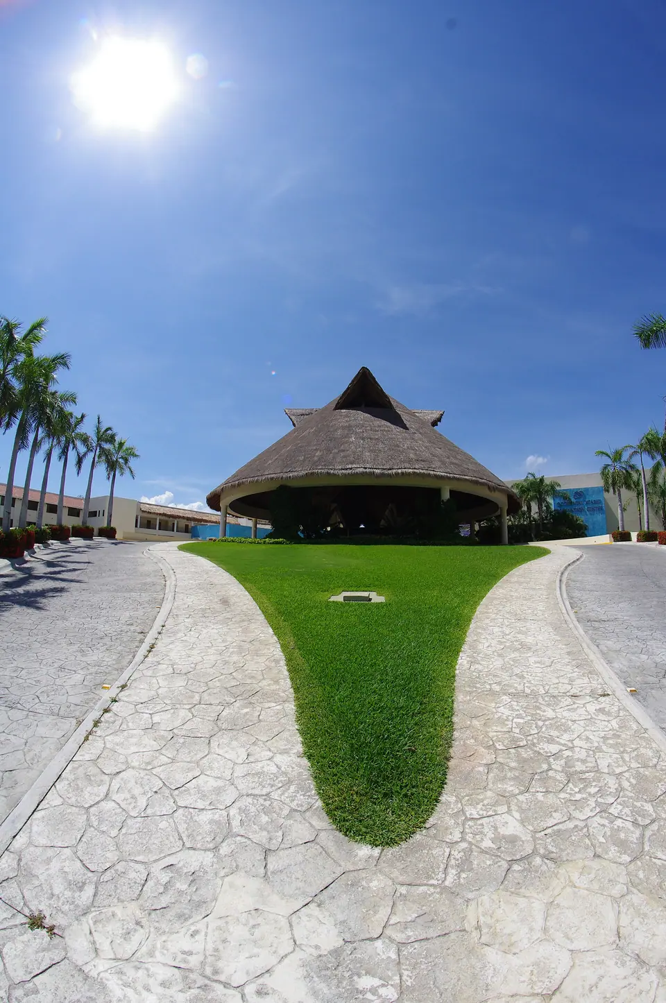 Large thatched palapa roof building surrounded by palms at Occidental Xcaret resort
