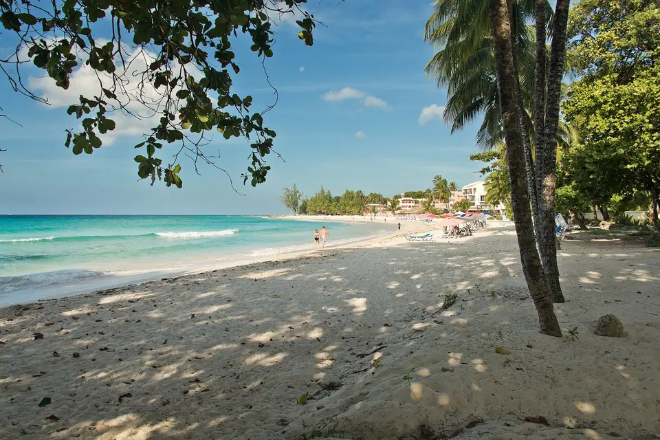 Shaded sandy path and wide beach at Dover Beach on the south coast with hotels in the distance