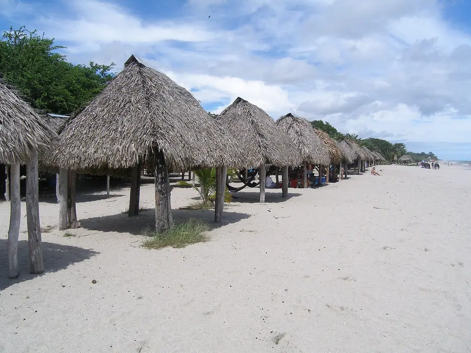 Thatched beach shelters along the sand at Santa Clara beach in Coclé, Panama