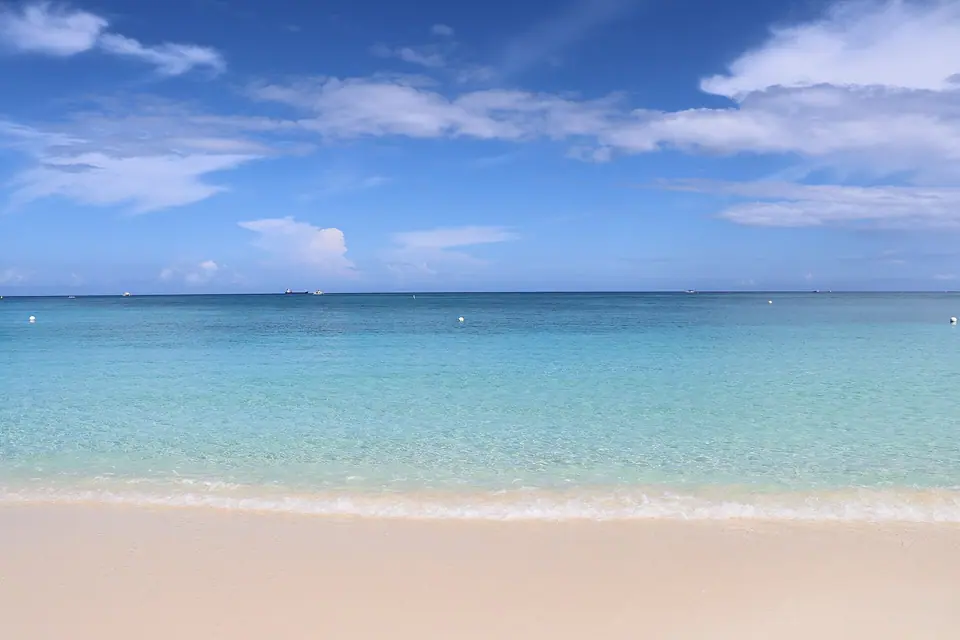 Wide white sand and turquoise water on Seven Mile Beach, Grand Cayman, looking west