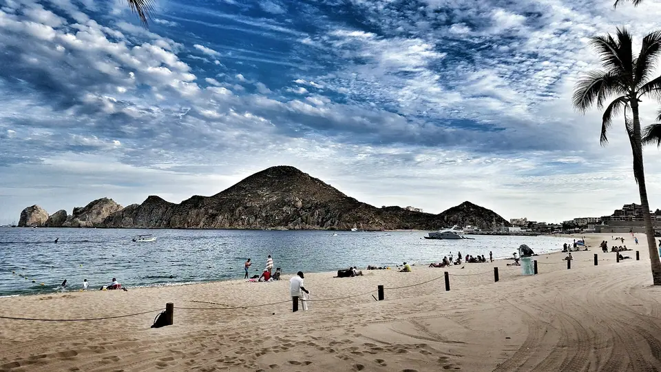 Calm water at Medano Beach with the rocky Land's End peninsula of Cabo San Lucas behind