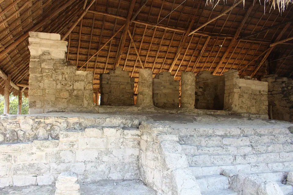 Stone walls and doorways of El Palacio at the San Gervasio Maya site on Cozumel, sheltered under a thatched roof