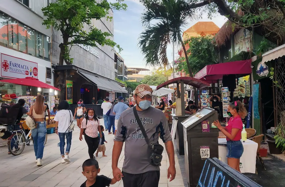 Pedestrians walking along shop-lined Quinta Avenida in Playa del Carmen