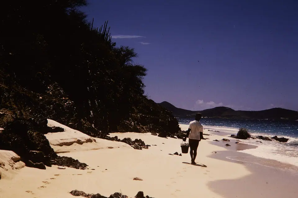 A visitor walking along the white-sand beach at Buck Island Reef National Monument off St. Croix