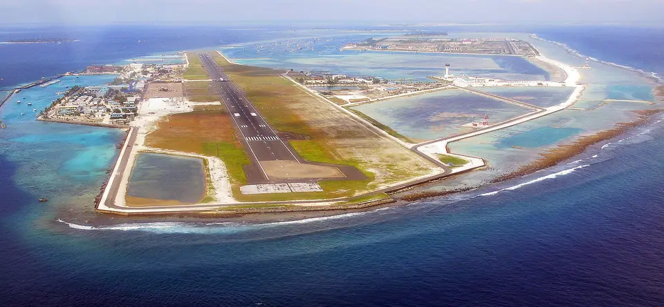 Aerial view of Velana International Airport runway on its island next to Malé
