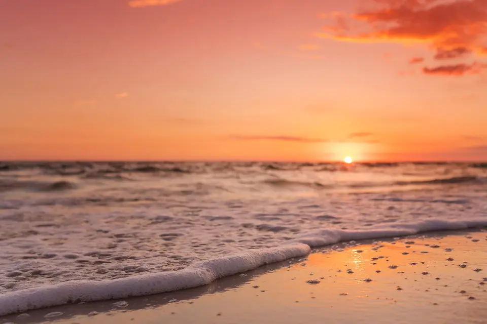 Sunset over the sand and Gulf of Mexico at a beach in Destin, Florida