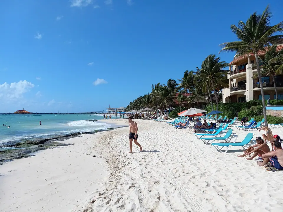 Sunbathers and calm turquoise water on the beach at Playa del Carmen