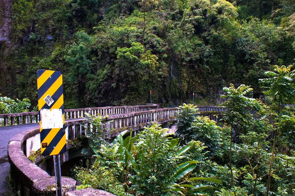 A narrow one-lane bridge surrounded by rainforest on the Hana Highway