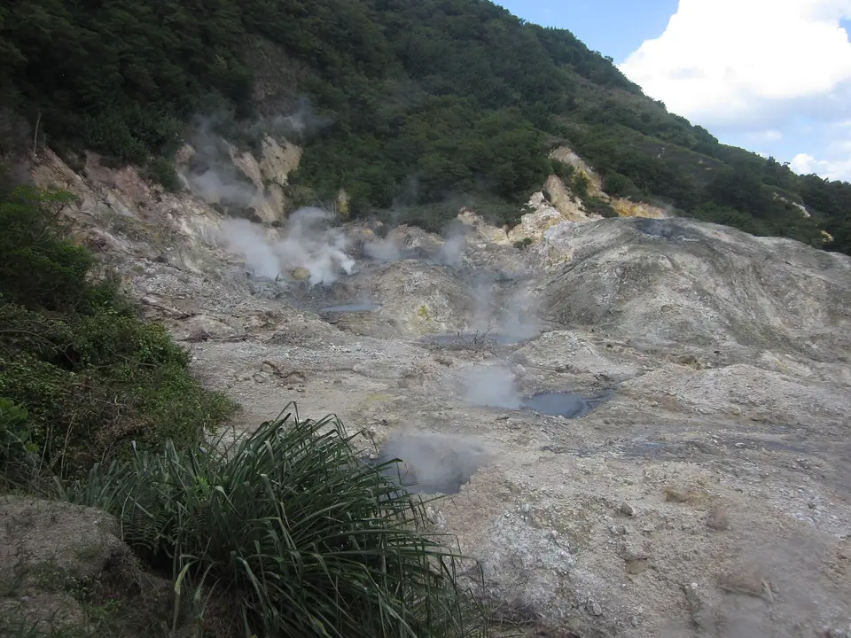 Steaming grey volcanic vents and mineral deposits at Sulphur Springs near Soufrière